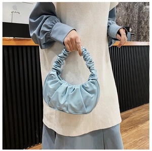 Close-up of light blue pleated cloud bag showing crescent shape and matte texture