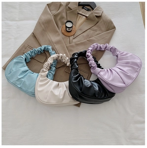 Vue à plat de sacs nuage plissés en bleu ciel, beige, noir et violet sur blazer brun