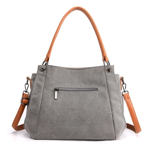 Minimalist grey canvas tote bag with brown leather handles and adjustable shoulder strap