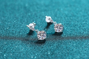 Macro shot of S925 sterling silver studs with six-prong moissanite inlay on blue glitter