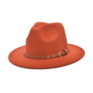 Detailed view of orange wool fedora with brown leather band and gold stud embellishments