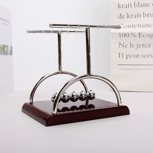 Macro view of five silver steel balance balls and a deep red wooden base Newton's cradle