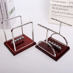 Detailed view of Newton's Cradle with mahogany base and polished silver metal balance balls