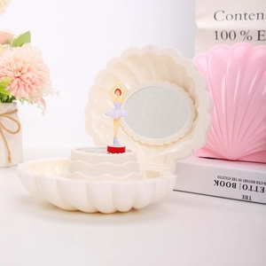Detail view of the shell-shaped music box with a rotating ballerina and makeup mirror