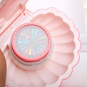 Detail of pink shell music box showing colorful inner design and iridescent cover