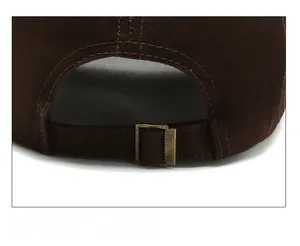 Detail of adjustable metal buckle and cotton strap on the back of brown baseball cap