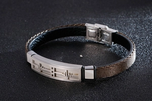 Macro detail of heartbeat engraved stainless steel plaque on a woven brown leather strap