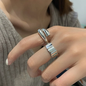 Silver wavy textured wide band and smooth spiral minimalist rings worn by model