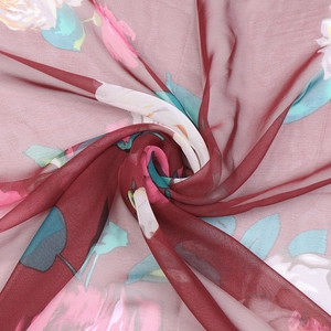 Macro detail of red georgette silk scarf showing floral print and soft fabric texture