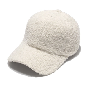 Detailed close-up of white fleece texture on a plush winter baseball cap for women