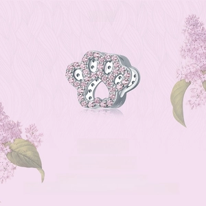 Macro shot of S925 sterling silver charm with pink paw print zircon inlay and floral decor