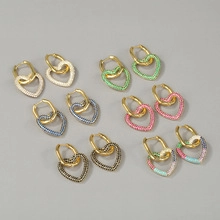 Detail view of heart-shaped hoop earrings with colorful pavé rhinestones in gold finish