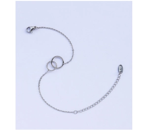 Silver double-circle bracelet featuring a K18 engraving on the tag and polished finish