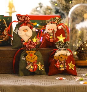 Detailed view of burlap Christmas drawstring gift bags with 3D plush doll characters