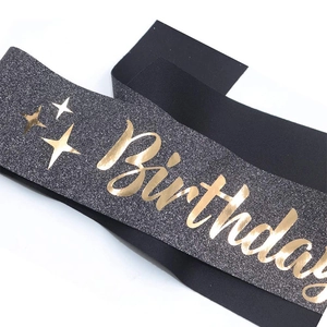 Close-up of black glitter Birthday sash with gold foil stars and elegant lettering