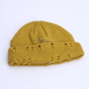 Yellow knit beanie with edgy distressed holes, punk safety pin and metal rings decor