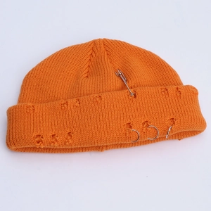 Detail of orange ribbed knit beanie featuring silver rings and trendy distressed hole design