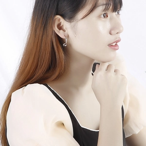 Boucles d'oreilles nœud en acier titane argenté portées par un mannequin femme