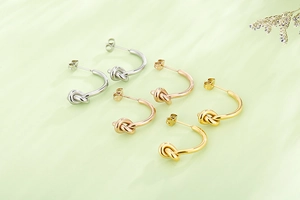 Trois paires de boucles d'oreilles créoles nouées en acier titane, or, argent et rose