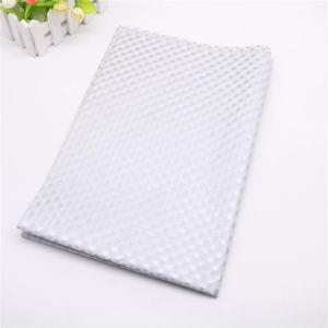 Close-up of white silk paper with gold foil polka dots for elegant gift wrapping