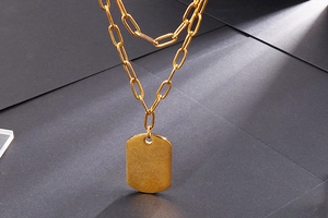 Detail view of double-layer gold military tag pendant with fine and chunky link chains