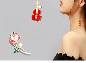 Detail of retro red cello and rose brooches with matching long pearl tassel earrings