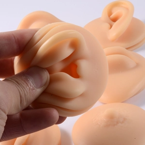 Close-up showing the soft flexibility of a silicone ear piercing training model