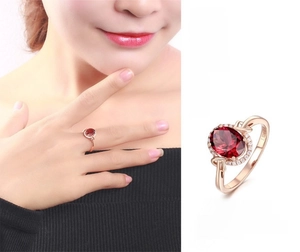 Detail view of 18k rose gold ring featuring 1.58ct oval ruby and halo diamonds