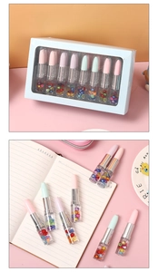 Detail of 10-piece creative lipstick pens with colorful beads in clear barrel on notebook