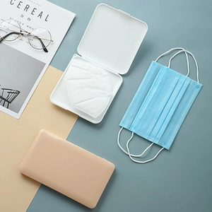 Portable matte plastic mask storage case in white and beige with flip-top lid detail