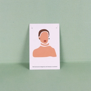 Detail of small dark stud earrings displayed on a white illustrative jewelry card
