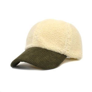 Close-up of white sherpa fleece baseball cap with olive green corduroy brim detail