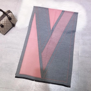 Detail of pink and grey geometric triangle patterned scarf with soft fringe edges
