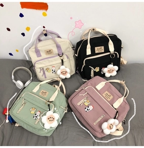 Flat lay of Japanese style canvas backpacks in off-white, black, green and pink colors