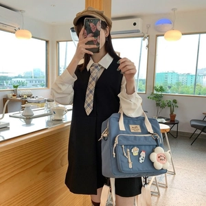 Blue canvas tote bag with floral pendant and cute cartoon pins in a cafe mirror selfie