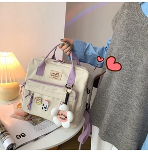 Detail of canvas tote bag with milk box badge and plush flower pendant accessories