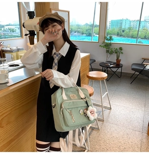 Detail of light green nylon student backpack with floral charm and JK style badges
