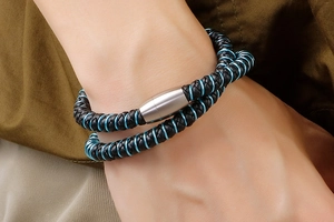 Détail du bracelet double en cuir noir avec fil métallique bleu et fermoir magnétique