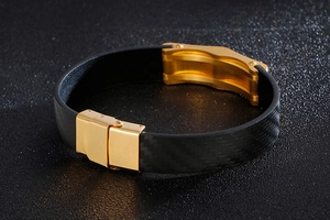 Detailed close-up of men's black woven leather bracelet with golden stainless steel clasp