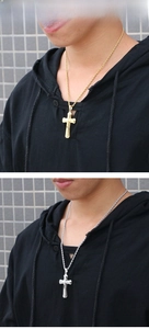 Close-up of gold and silver cross pendants on twisted rope chains worn by a male model