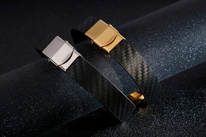 Detail of black carbon fiber weave bracelets with gold and silver geometric clasps