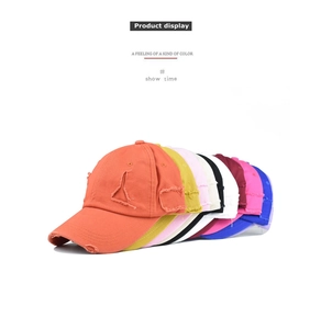 Detail view of distressed cotton baseball caps in multiple colors with ripped brims