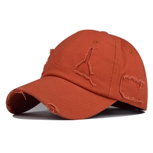 Detail of distressed baseball cap showing torn fabric texture and frayed brim style