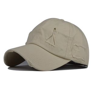 Detailed view of the distressed ripped brim on a vintage washed cotton baseball cap