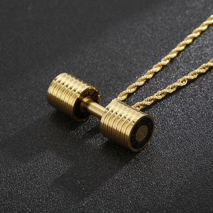 Detailed macro view of a golden barbell pendant featuring Go Fit engraving and twist chain