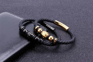 Detail of woven leather bracelets with embossed metal beads and snap button closure