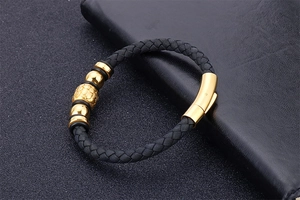 Detail of men's braided black leather bracelet with polished golden stainless steel clasp