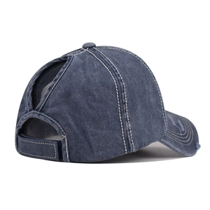 Dettaglio cappellino da baseball blu denim con apertura per coda e cuciture a contrasto