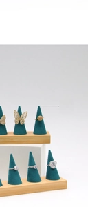 Bamboo and green velvet ring display stands with gold and silver jewelry on top