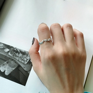 Detail of twisted rope texture 925 silver ring worn on index finger for daily fashion
